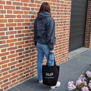 Black Eco tote bag with the message dear stranger, be kind to yourself and dark gray hoodie with the message one act of kindness can make a big difference. Be the reason someone feels seen today